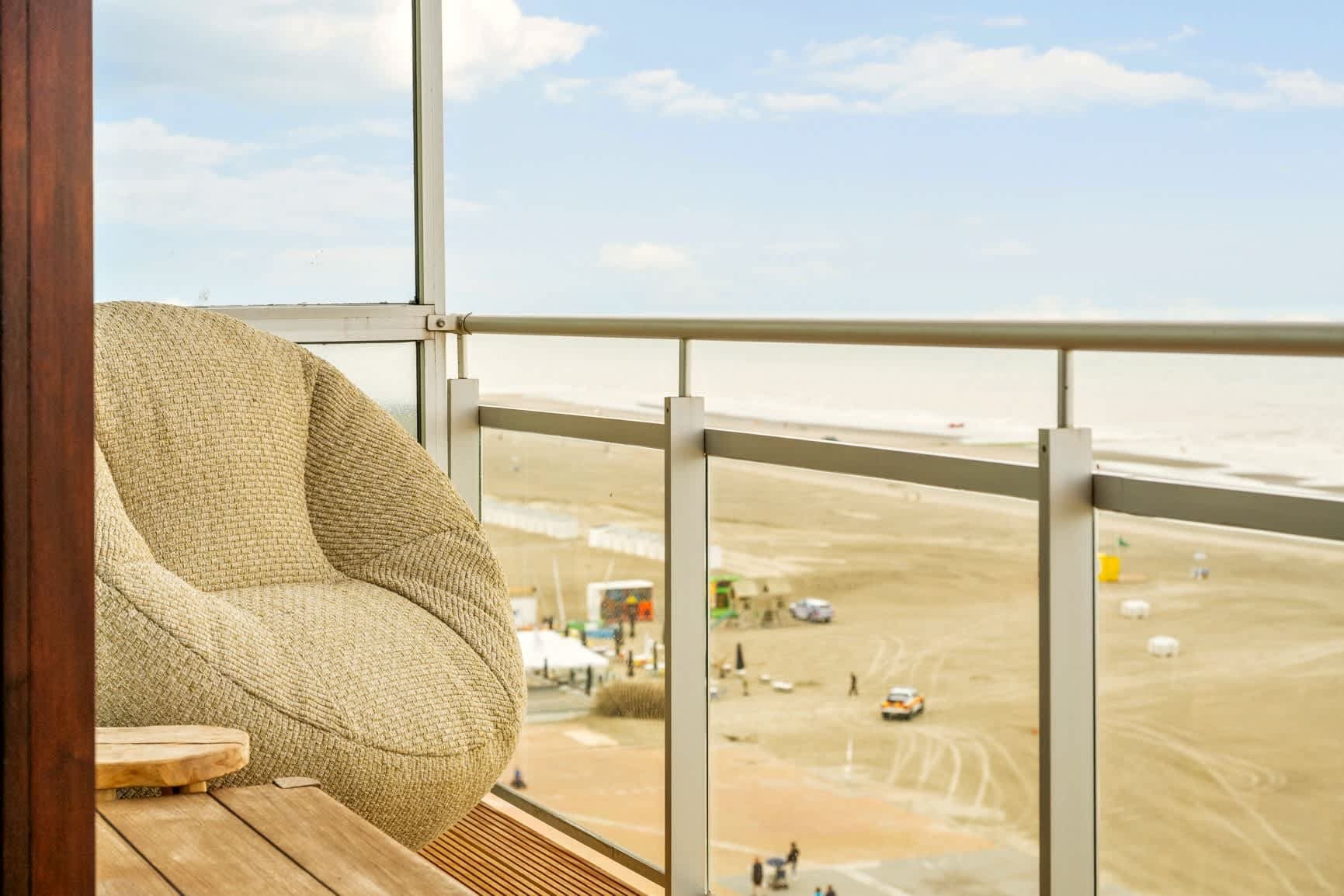 Loungestoel op het zeebalkon, het strand acht verdiepingen lager.