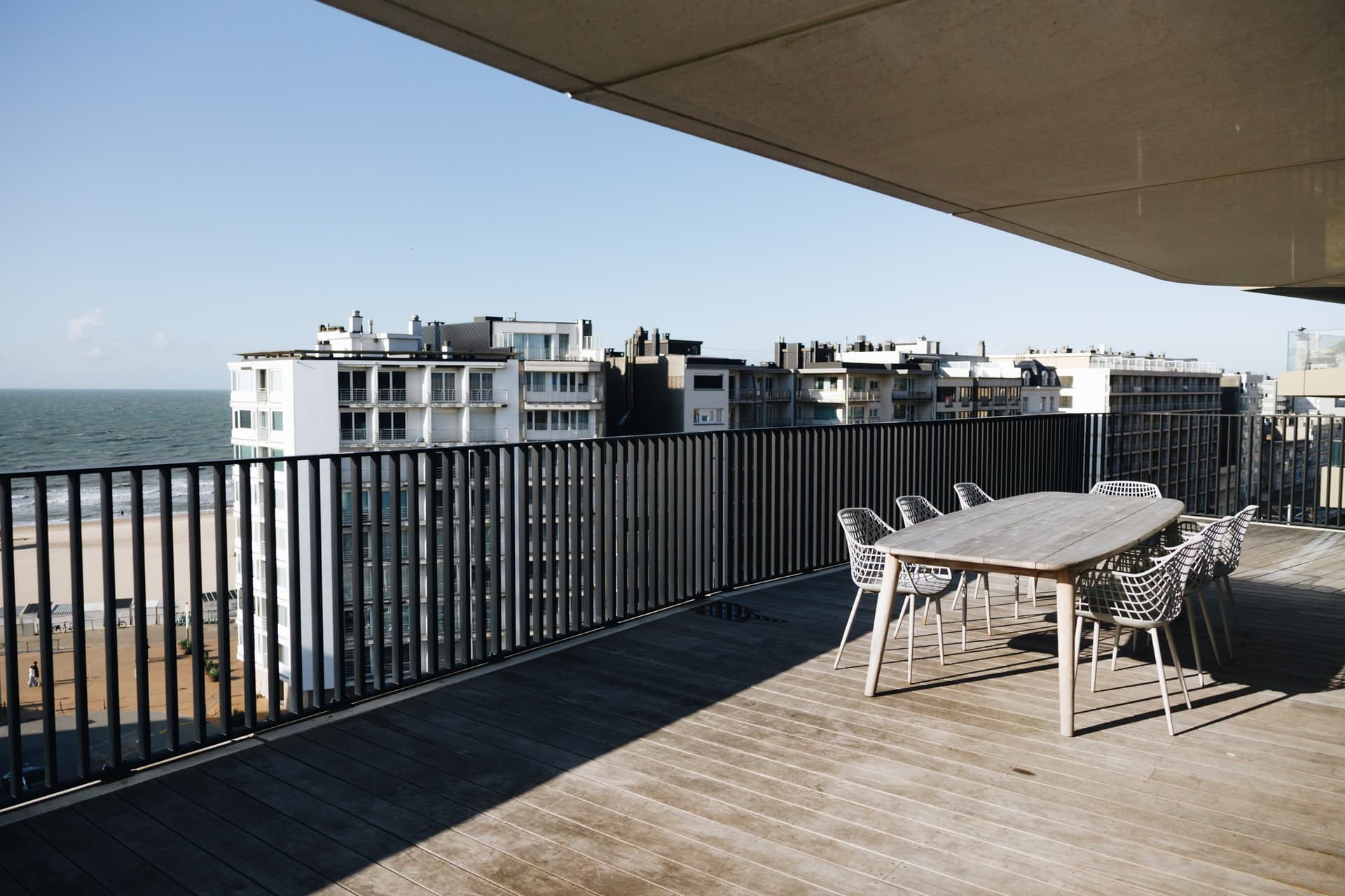 Terras met buitentafel, zicht op zee en de dijk.