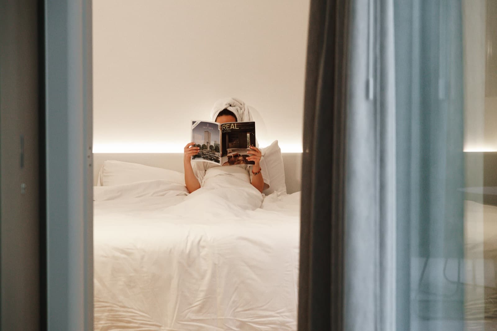 bed met tijdschrift en handdoek om het hoofd gedraaid